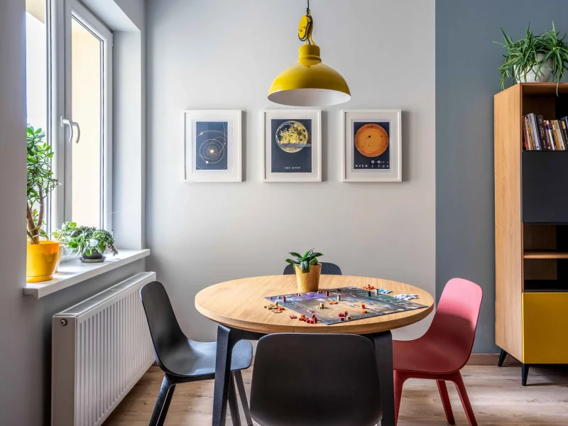 salon ze stolem drewnianym i zolta lampa w mieszkaniu w nowej hucie